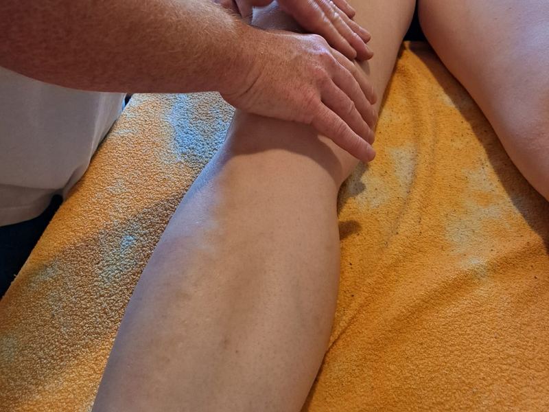 Ruční lymfodrenáž dolních končetin, jemné hmaty oběma dlaněmi po lýtku a stehně