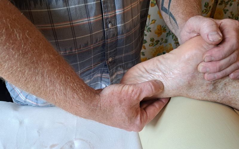 Reflexní terapie chodidla, Tomáš Kestner tlačí palcem na reflexní bod na plosce nohy